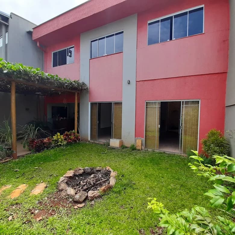 Quintal do Espaço Cor com jardim, pergolado e as portas de vidro do salão